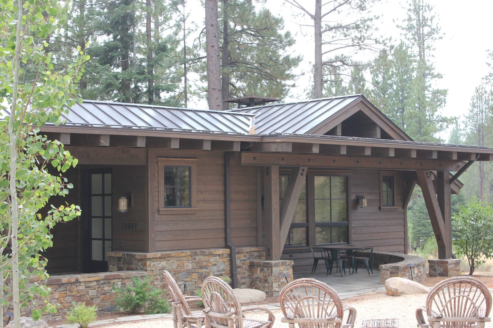 Custom mountain home with timber porch stone base metal roof and outdoor seating Truckee CA