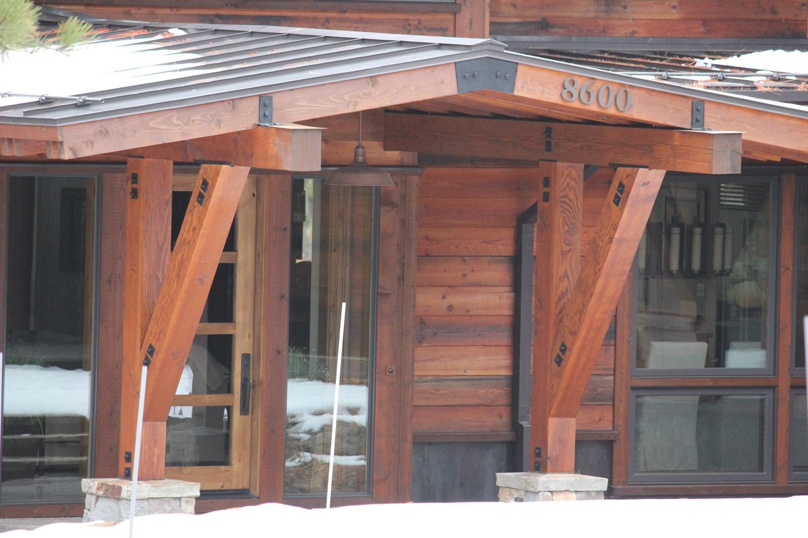 Custom home exterior timber brackets reclaimed wood siding and stone base Martis Camp Truckee CA