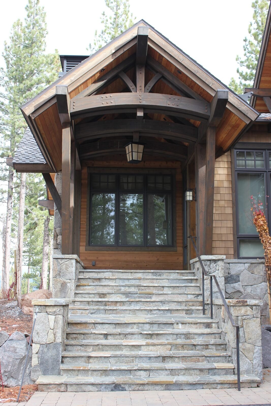 Heavy timber frame entry porch with stone steps and cedar shingle siding Martis Camp Truckee CA