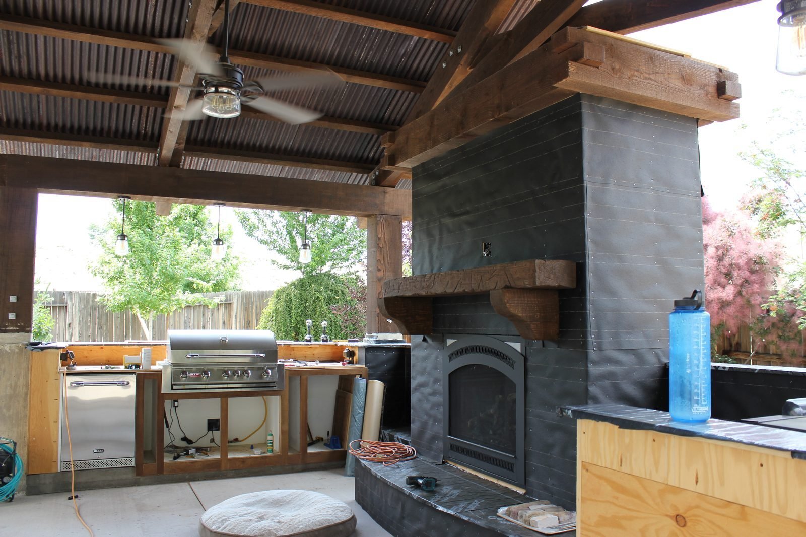 Covered outdoor kitchen with BBQ grill fireplace and timber frame build Reno NV